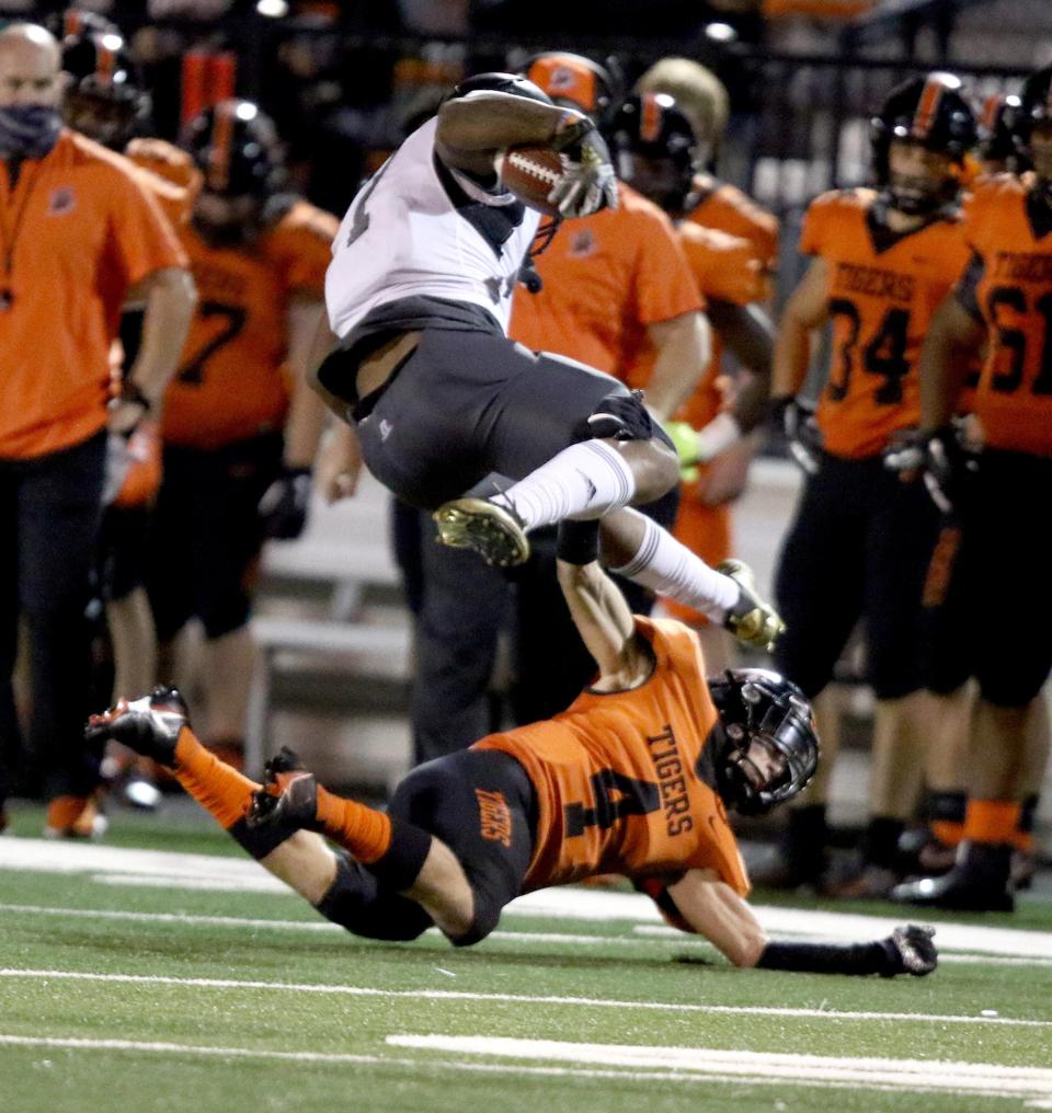 Massillon's Austin Brawley (4) takes out the legs of Bishop Sycamore's Daivon Lowman during a September 2020 game.