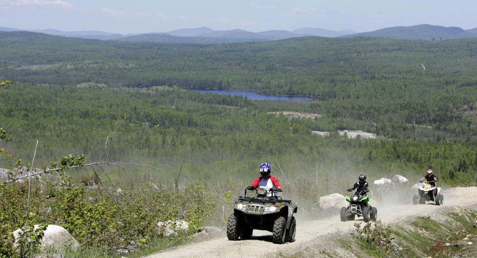 FILE - In this Sunday, May 23, 2010 file photo, Jude Stohl leads Leigha Cicchetto, and his son Ethan Stohl on a ride through Jericho Park's trail system in Berlin, N.H. In New Hampshire, a new interconnected all-terrain vehicle trail system dubbed "Ride the Wilds" will officially open June 15, 2013 capping years of work by more than a dozen off-road vehicle clubs who worked with state agencies and local communities to link 1,000 miles of trails across Coos County. (AP Photo/Jim Cole, File)