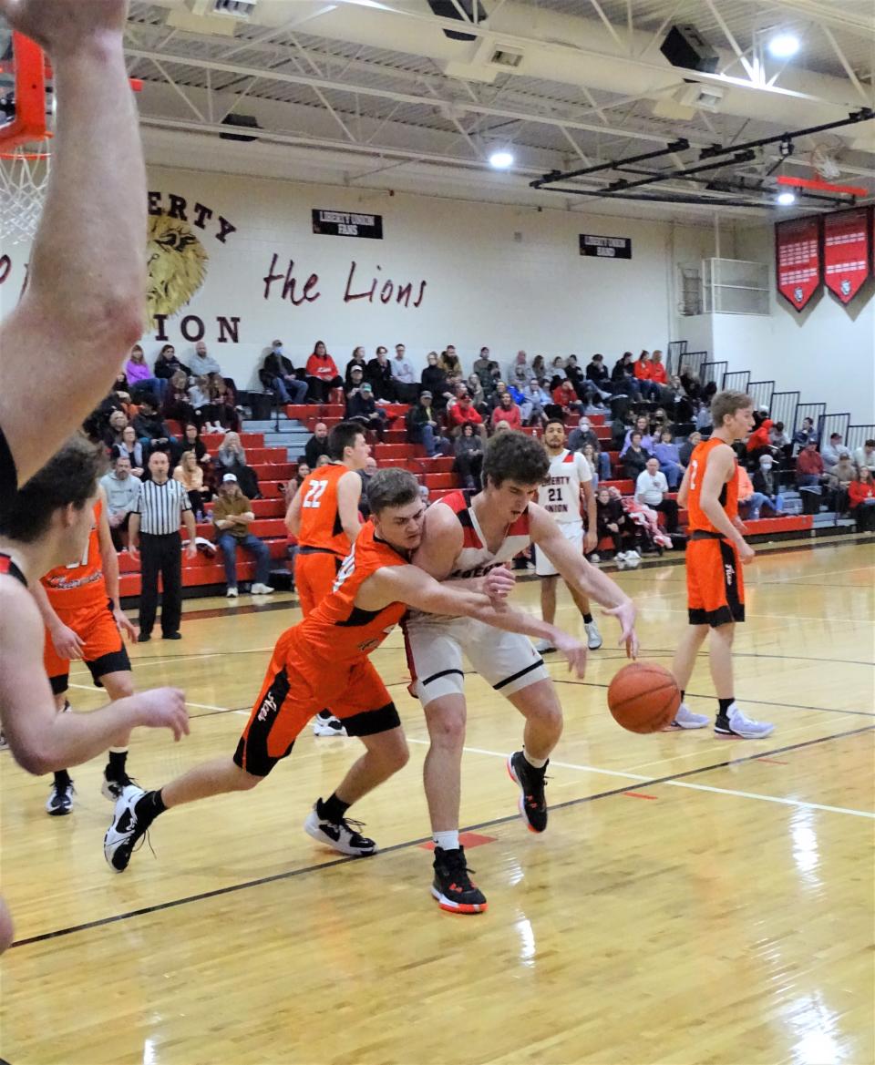 Amanda-Clearcreek's Cade Young knocks the ball away from Liberty Union's Jacob Denney during the Lions' 52-47 win Saturday night.