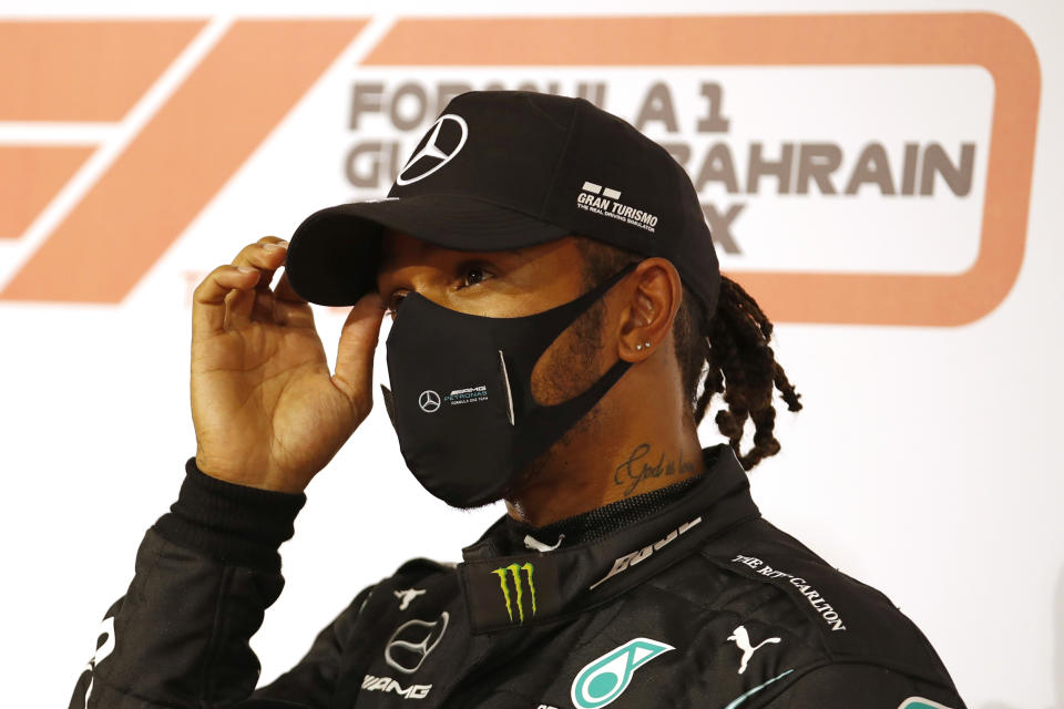 FILE - In this Saturday, Nov. 28, 2020 file photo Mercedes driver Lewis Hamilton of Britain gestures after taking the pole position after the qualifying session at the Formula One Bahrain International Circuit in Sakhir, Bahrain. World champion Lewis Hamilton tested positive for COVID-19 and will miss the Sakhir Grand Prix this weekend, his Mercedes-AMG Petronas F1 Team said Tuesday Dec. 1, 2020. (Hamad Mohammed, Pool via AP, File)