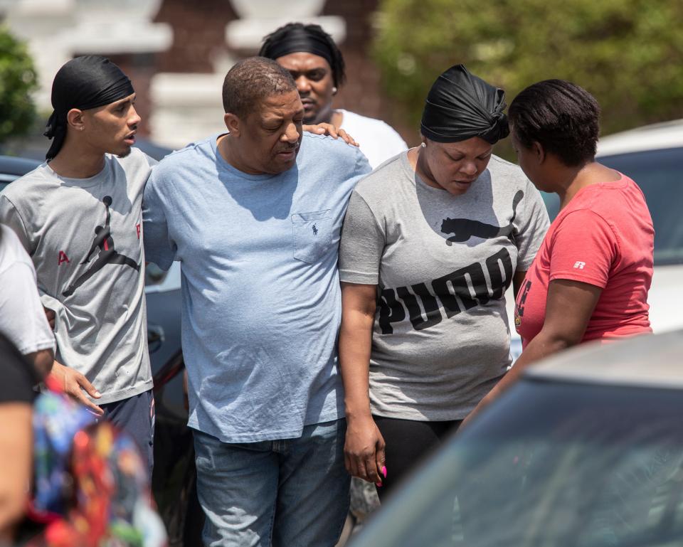 Loved ones are consoled Friday after a man's fatal shooting by federal law enforcement on Sutcliffe Avenue in Louisville's West End neighborhood.