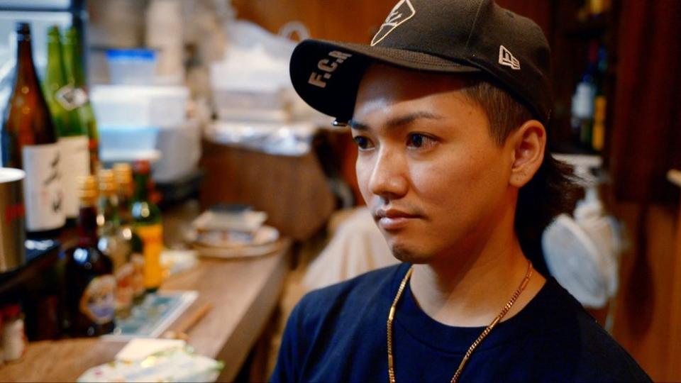 El joven Ryu en un bar con gorra de béisbol.