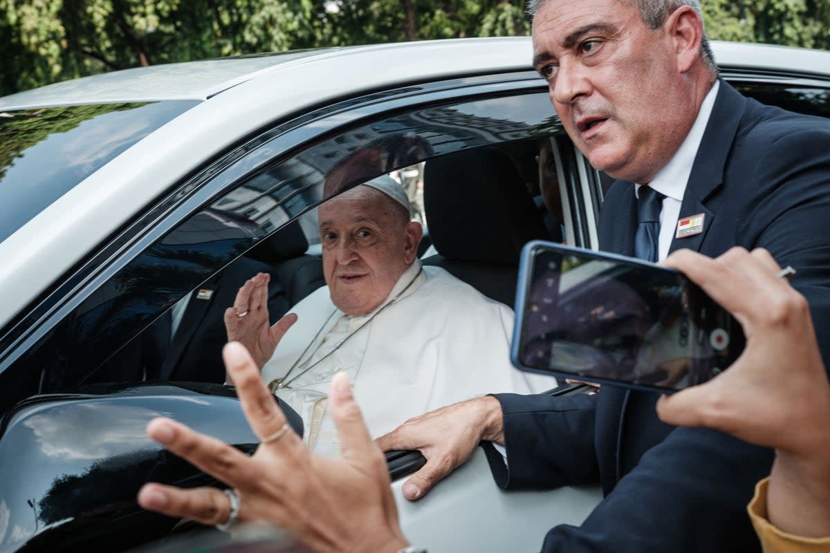 Pope Francis and security react as he leaves Vatican's diplomatic mission in Jakarta (AFP via Getty Images)