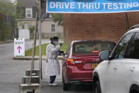 FILE - In this Oct. 21, 2020, file photo, medical personnel prepare to administer a COVID-19 swab at a drive-through testing site in Lawrence, N.Y. The United States is approaching a record for the number of new daily coronavirus cases in the latest ominous sign about the disease's grip on the nation. (AP Photo/Seth Wenig, File)