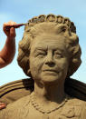 WESTON-SUPER-MARE, ENGLAND - MAY 28: Sand sculpture artist Nicola Wood completes a sand sculpture she has created of Queen Elizabeth II at the annual Weston-super-Mare Sand Sculpture festival on May 28, 2012 in Weston-Super-Mare, England. Now in its seventh year, the festival, which opens to the public on Friday, features sand sculptures from award-winning artists from across the globe. Using 4000 tonnes of Weston beach sand this year's giant sand art display, created by 15 international artists on the theme Fun and Games, runs throughout the summer until September 9. (Photo by Matt Cardy/Getty Images)