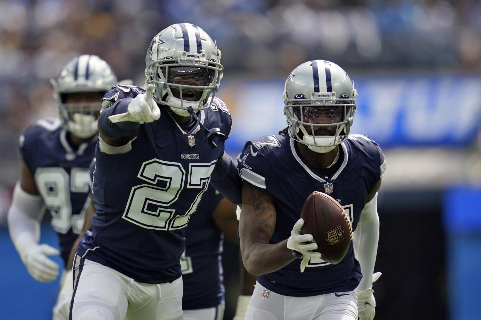 Dallas Cowboys cornerback Tevon Diggs, right, runs back with an intercepted pass next to safety Jayron Kearse (27) during the first half of an NFL football game against the Los Angeles Chargers Sunday, Sept. 19, 2021, in Inglewood, Calif. (AP Photo/Ashley Landis )