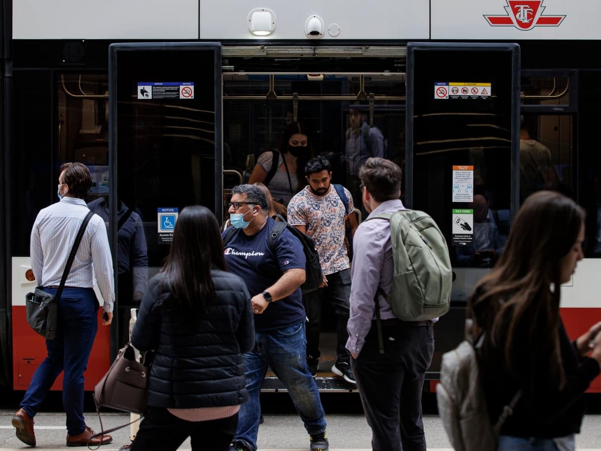 Transit riders take a streetcar on King St., in downtown Toronto, on June 8, 2022. Ontario lifts mandatory mask rules on transit and in hospitals starting June 11. (Evan Mitsui/CBC - image credit)