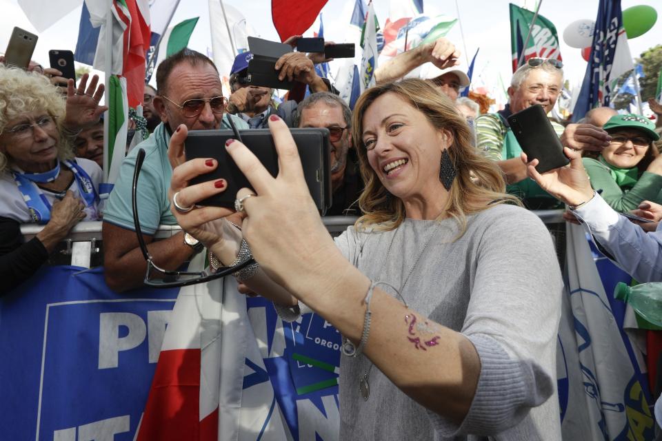 FILE — Brothers of Italy's party leader, Giorgia Meloni, takes a selfie with supporters during a rally in Rome, Saturday, Oct. 19, 2019. With God, homeland and "natural" family prominent in her political manifesto, Giorgia Meloni, whose Fratelli d'Italia (Brothers of Italy) party with neo-fascist roots has been fast rising in popularity in view of the upcoming Sept. 25 elections for Parliament, is positioning herself to become Italy's first far-right premier and the first woman to hold that office. (AP Photo/Andrew Medichini)