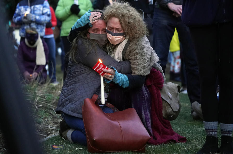 Mourners hug at a vigil for the victims of a mass shooting at a grocery store earlier in the week, Wednesday, March 24, 2021, outside the courthouse in Boulder, Colo. (AP Photo/David Zalubowski)