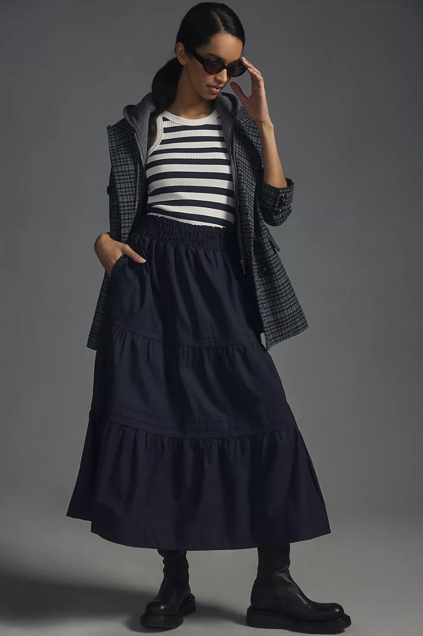 model wearing black boots, striped shirt, grey blazer and The Somerset Maxi Skirt in navy (photo via Anthropologie)