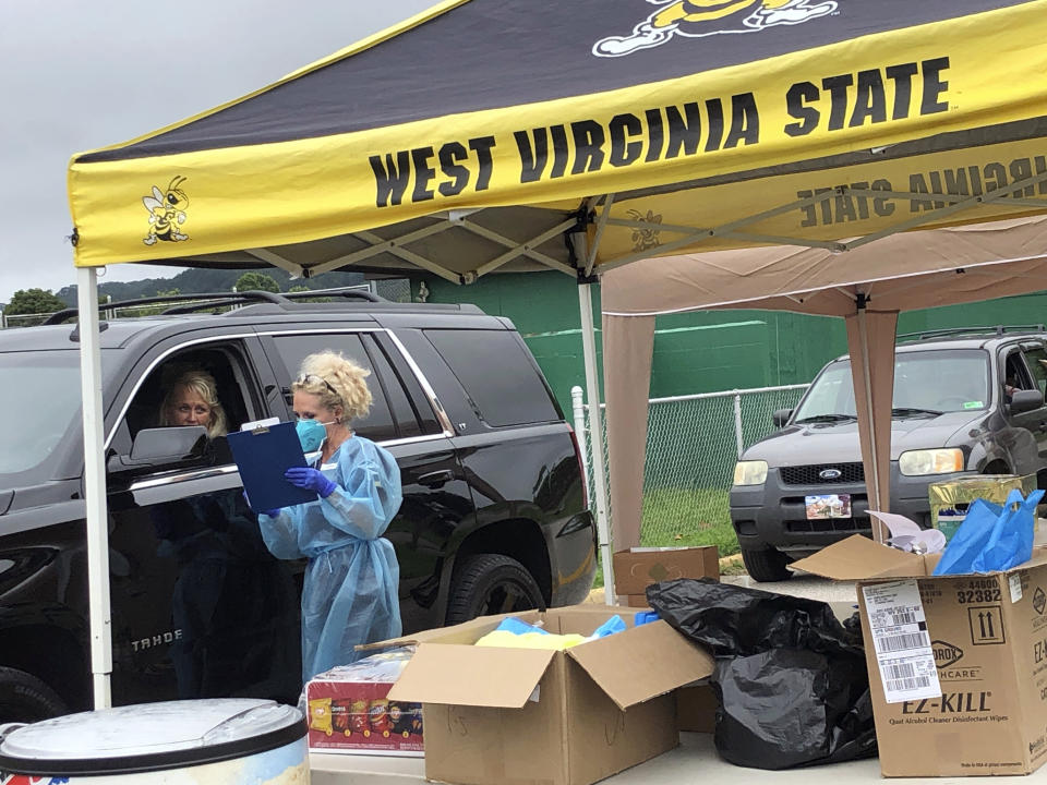 Parents and students arrive in their vehicles for health screenings and temperature checks before moving belongings into residence halls at West Virginia State University campus Friday, July 31, 2020, in Institute, W. Va. The first wave of college students returning to their dorms aren’t finding the typical mobs of students and parents. What they found Friday were strict safety protocols and some heightened anxiety amid a global pandemic where virus infections are growing in dozens of states. (AP Photo/John Raby)