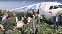 In this file image taken from a video distributed by Russian Investigative Committee, Investigative Committee employees work at the crash site of a Russian Ural Airlines' A321 plane is seen after an emergency landing in a cornfield near Ramenskoye, outside Moscow, Russia, Thursday, Aug. 15, 2019. The Russian pilot was being hailed as a hero Thursday for safely landing his passenger jet in a corn field after it collided with a flock of gulls seconds after takeoff, causing both engines to malfunction. While dozens of people on the plane sought medical assistance, only one was hospitalized. (The Investigative Committee of the Russian Federation via AP) EDS NOTE: Watermark placed on image at source translated as InvestCom