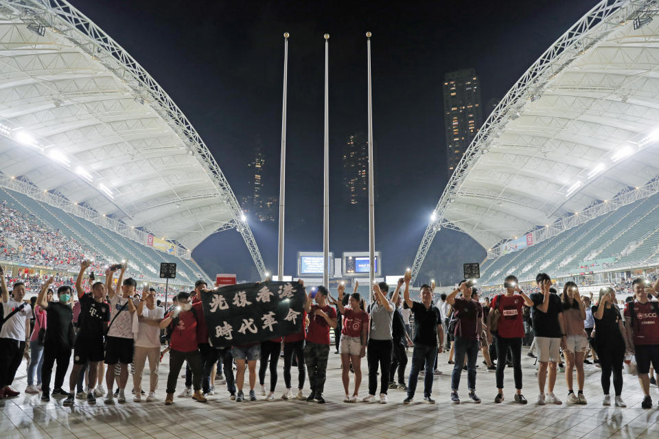 Hong Kong soccer fans form human chain and chant banner reads "Liberate Hong Kong, Revolution of Our Times." during the FIFA World Cup Qatar 2022 and AFC Asian Cup 2023 Preliminary Joint Qualification Round 2 soccer match between Hong Kong and Iran, in Hong Kong, Tuesday, Sept. 10, 2019. The crowd broke out into "Glory to Hong Kong," a song reflecting their campaign for more democratic freedoms in the semi-autonomous Chinese territory. (AP Photo/Kin Cheung)