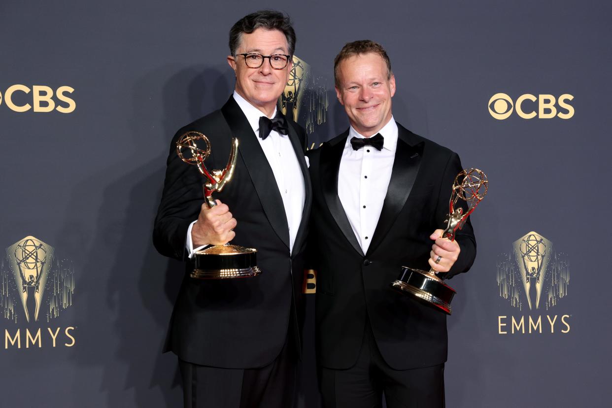 Two men pose with Emmy awards.