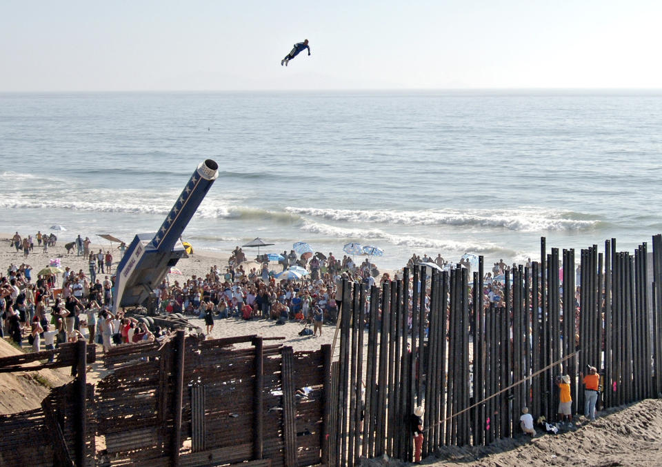 FILE - David “The Human Cannonball” Smith Jr. flies over the U.S.-Mexico border fence from the Playas de Tijuana area of Tijuana, into San Diego, during an arts festival in Aug. 27, 2005. (AP Photo/Denis Poroy, File)