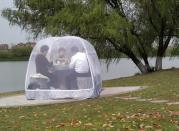 People enjoy a meal inside a tent to prevent the novel coronavirus disease (COVID-19), at a park in Nanjing, Jiangsu