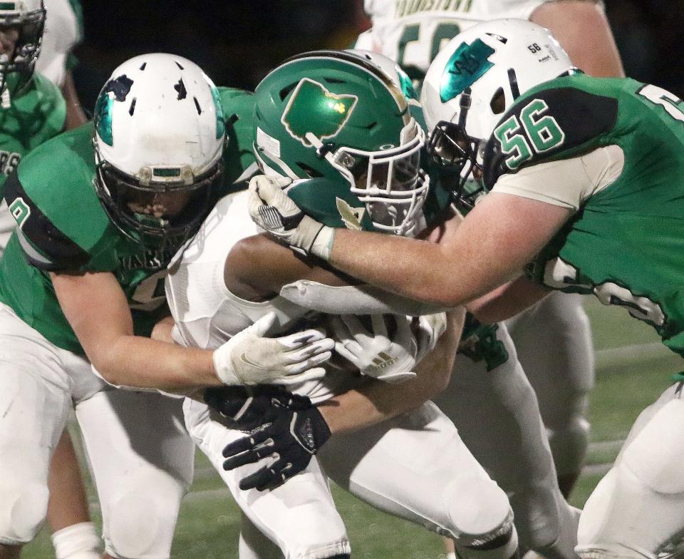 West Branch's Steven Marra, left, and Mitchell Coffee, right, bring down Ursuline running back Christian Lynch during the Division IV regional final at South Range Raiders Stadium Friday, November 19, 2021.