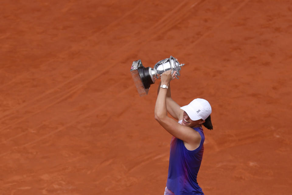 Poland's Iga Swiatek celebrates with the trophy as she won the women's final of the French Open tennis tournament against Italy's Jasmine Paolini at the Roland Garros stadium in Paris, France, Saturday, June 8, 2024. (AP Photo/Jean-Francois Badias)