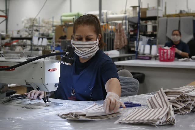 Factory workers sew face masks