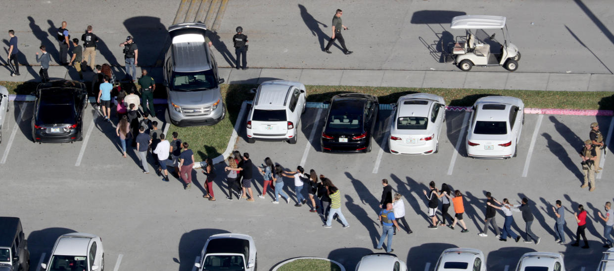 A long line of students is evacuated through the parking lot at Marjory Stoneman Douglas High School.