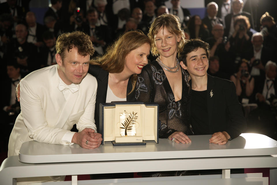 Justine Triet, winner of the Palme d'Or for 'Anatomy of a Fall,' second from left, Antoine Reinartz, from left, Sandra Huller and Milo Machado Graner pose for photographers during a photo call following the awards ceremony at the 76th international film festival, Cannes, southern France, Saturday, May 27, 2023. (AP Photo/Daniel Cole)