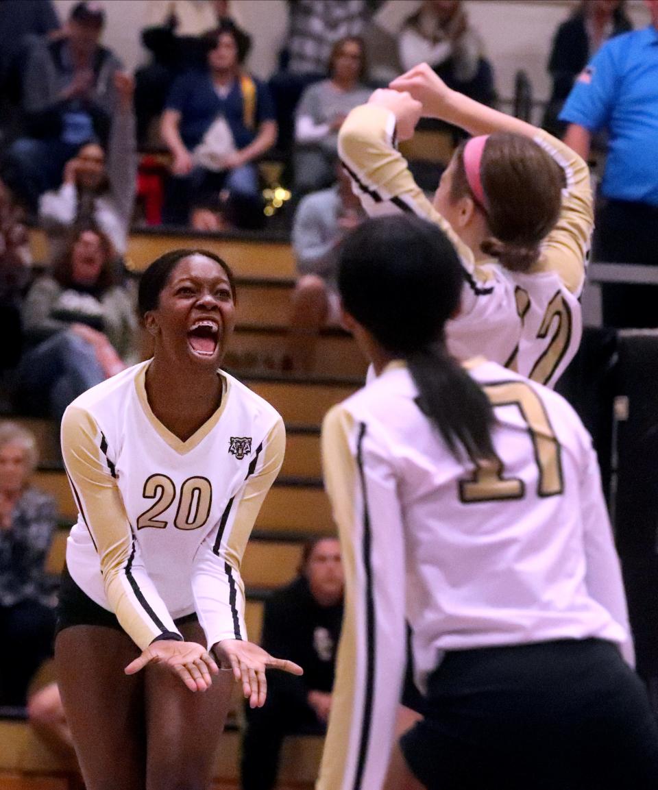 Central's Noella Obi (20) celebrates her kill against Sycamore with Central's Rylee Zeller (12) and Central's Bella Donaldson (17) during the Class AA  volleyball sectionals on Thursday, Oct. 13, 2022, at Central.