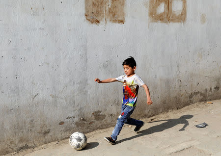 Murtaza Ahmadi, 7, an Afghan Lionel Messi fan, plays football outside his house in Kabul, Afghanistan December 8, 2018.REUTERS/Mohammad Ismail