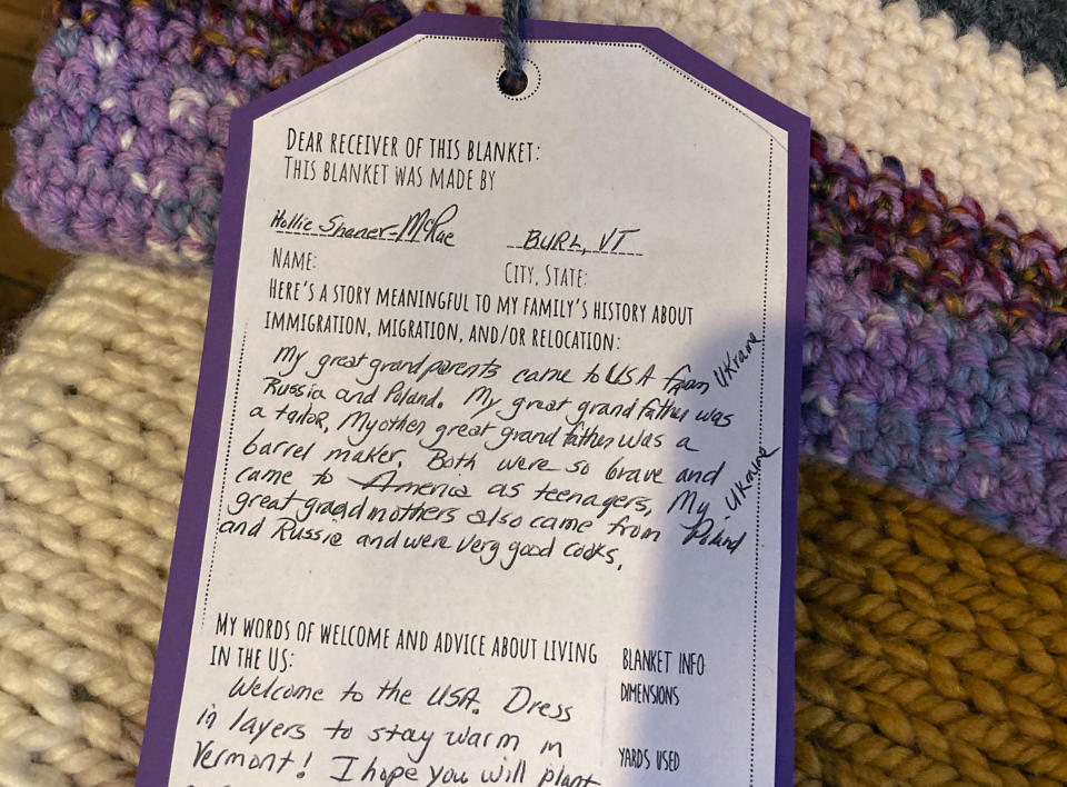 A personalized note is attached to a handmade blanket that was among dozens of blankets made for refugees in the Welcome Blanket exhibit, at the Winooski Heritage Mill Museum, Feb. 17, 2023, in Winooski, Vt. The blankets with notes from the creators, sharing their own family's history about immigration, were given away to refugees. (AP Photo/Lisa Rathke)