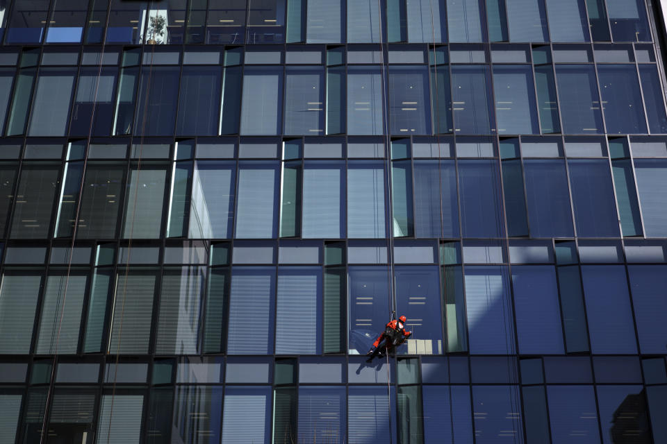 In this Jan. 10, 2018 photo, a worker cleans windows of an office building in Tokyo. The Japanese government says the economy grew at an annual pace of 2.1% in the first quarter, marking the second straight quarter of expansion. The Cabinet Office said Monday, May 20, 2019, seasonally adjusted real gross domestic product, the total value of a nation’s goods and services, grew 0.5% in the January-March period from the previous quarter.(AP Photo/Eugene Hoshiko)