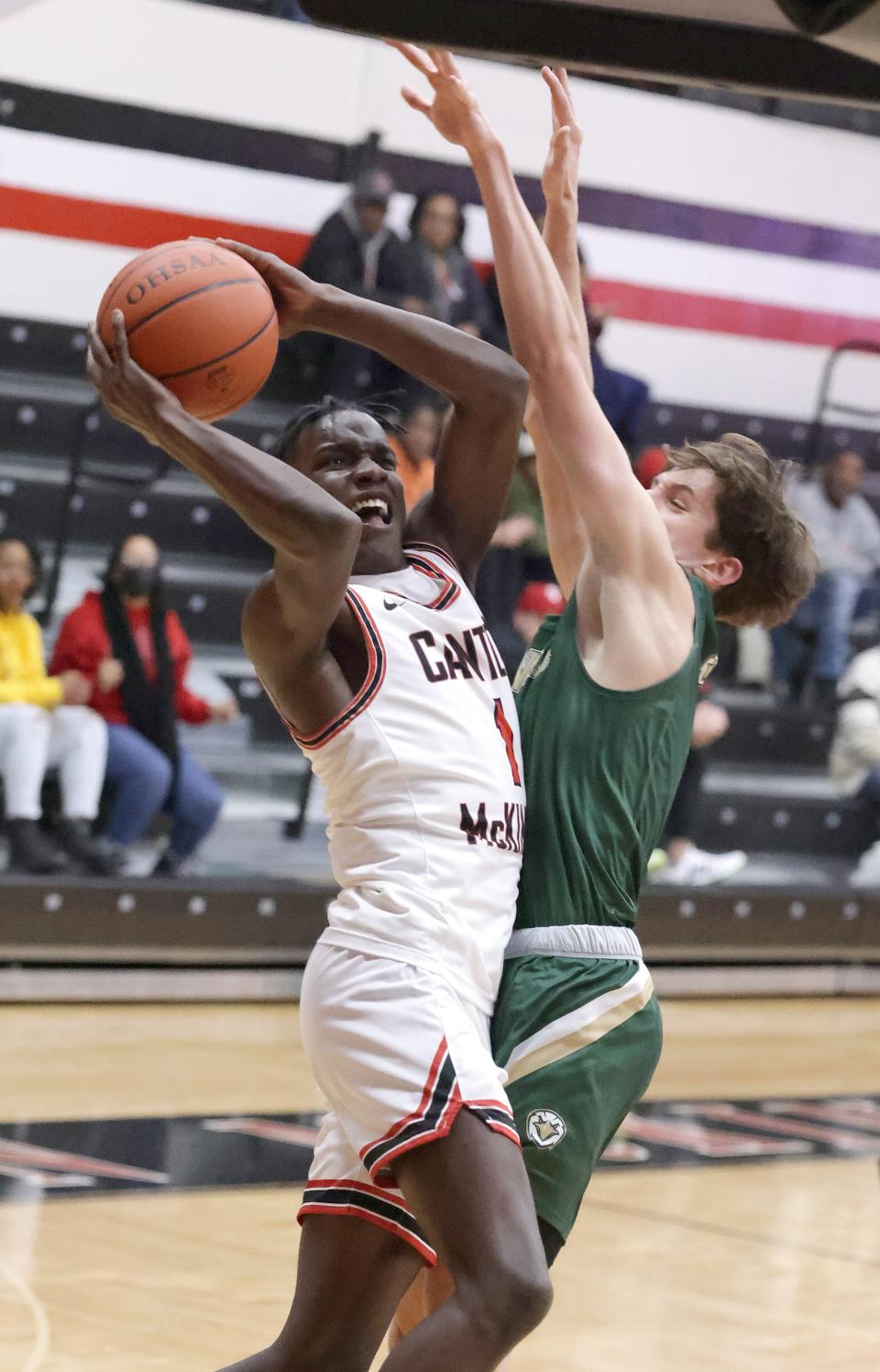 McKinley's Jecis Moody puts up a shot with pressure from GlenOak's Ben Davis in the first half at McKinley Friday, Feb. 18, 2022.