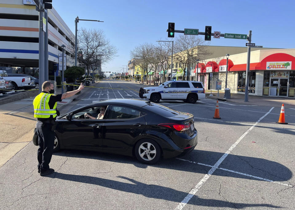 Virginia Beach police redirect traffic on Saturday, March 27, 2021 after late night shootings as they investigate a late night shooting in Virginia Beach, Va. A pair of overnight fatal shootings along the beachfront in Virginia Beach wounded several people in a scene described by authorities on Saturday as “very chaotic.” (Stephen Katz/The Virginian-Pilot via AP)