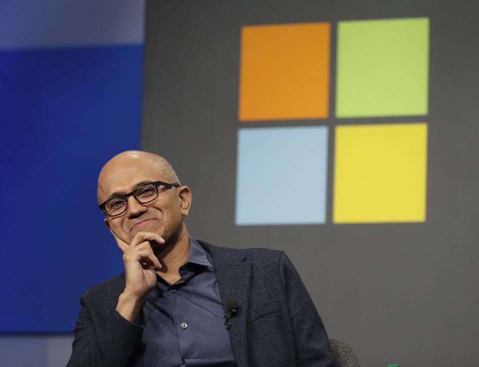 Microsoft CEO Satya Nadella listens to a question as he sits in front of the Windows logo during the annual Microsoft Corp. shareholders meeting, Wednesday, Nov. 28, 2018, in Bellevue, Wash. (AP Photo/Ted S. Warren)