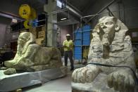 Egyptian archaeologists move statues of pharaohs at the new Grand Egyptian Museum near the Giza pyramids in Cairo on June 4, 2015