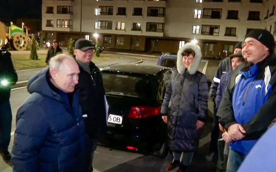 On a surprise visit to Mariupol, Russian President Vladimir Putin talks with local residents during his trip - POOL Russian TV/POOL Russian TV