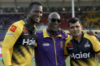 Peshawar Zalmi's players Darren Sammy, left, and Kamran Akmal, right, pose for photographer with former West Indies cricketer Vivian Richards, center, on end of Pakistan Super League T20 cricket match against Quetta Gladiators, in Karachi, Pakistan, Saturday, Feb. 22, 2020. Pakistan is making former West Indies captain Sammy an honorary citizen for his role in restoring international cricket to the country. Pakistan will also give Sammy its highest civilian award - Nishan-e-Pakistan - the Pakistan Cricket Board tweeted Saturday. (AP Photo/Fareed Khan)