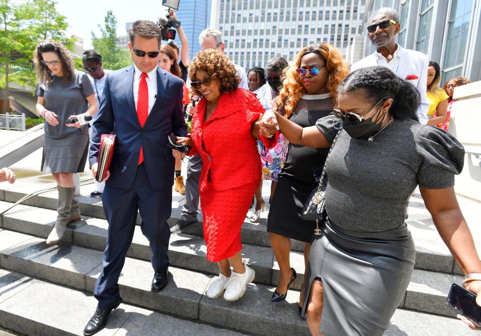 Former U.S. Rep. Corrine Brown is assisted down the stairs as she leaves Jacksonville's federal courthouse in 2022 after pleading guilty of one tax crime and being sentced to time served.