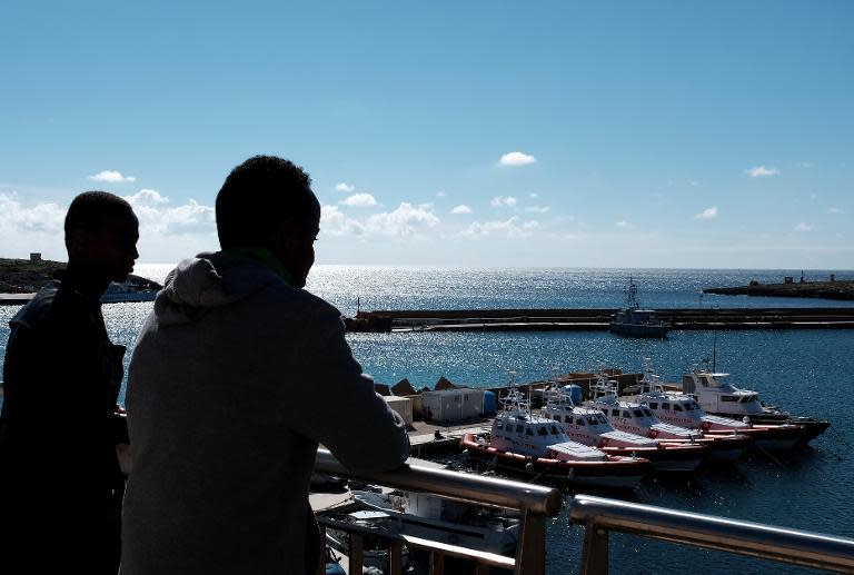 Somalian migrants look at the port of Lampedusa on February 17, 2015, a day after being rescued at sea