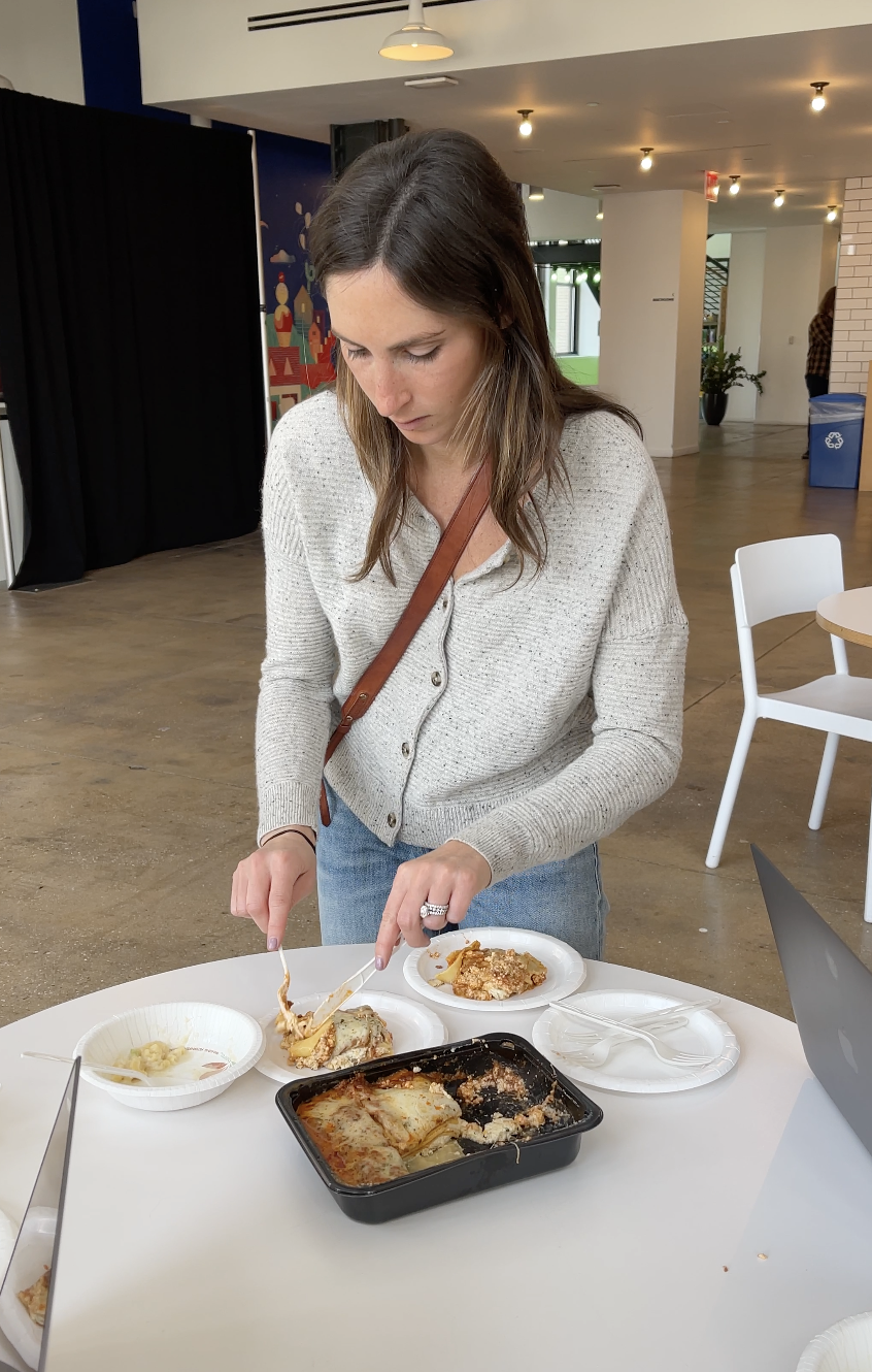 A woman serving plates of lasagna