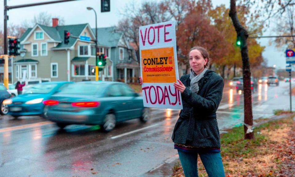 Campaigners hold signs outside a polling station Minneapolis, Minnesota on 6 November.