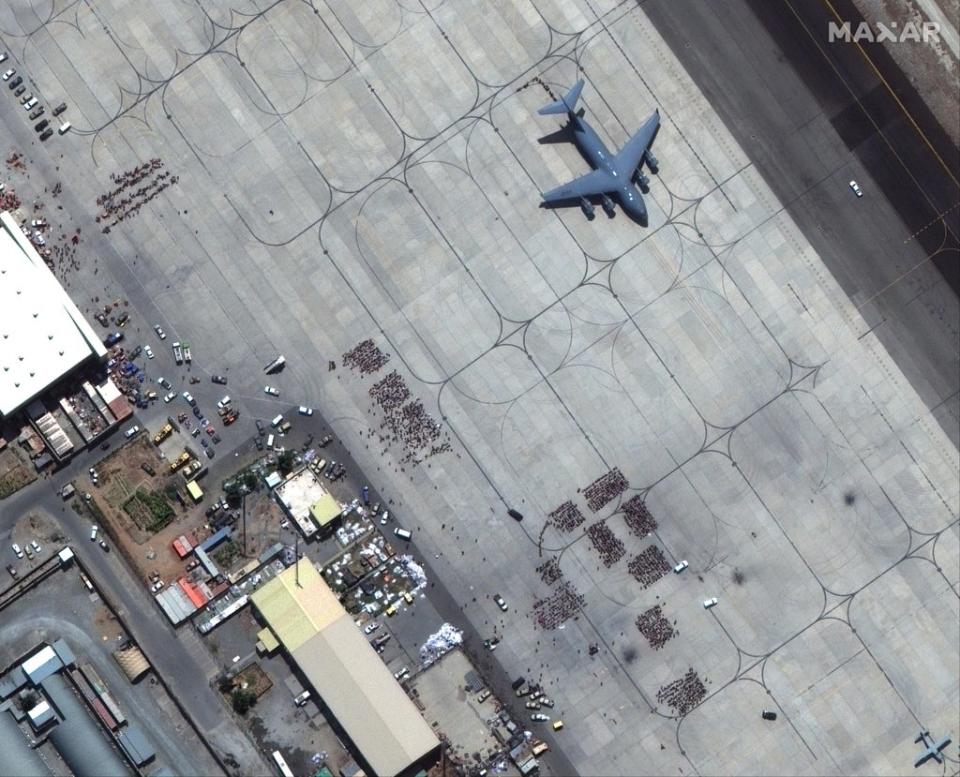 A satellite image shows groups of people waiting on the tarmac at Kabul Airport in Kabul, Afghanistan, 23 August 2021 (EPA-EFE)