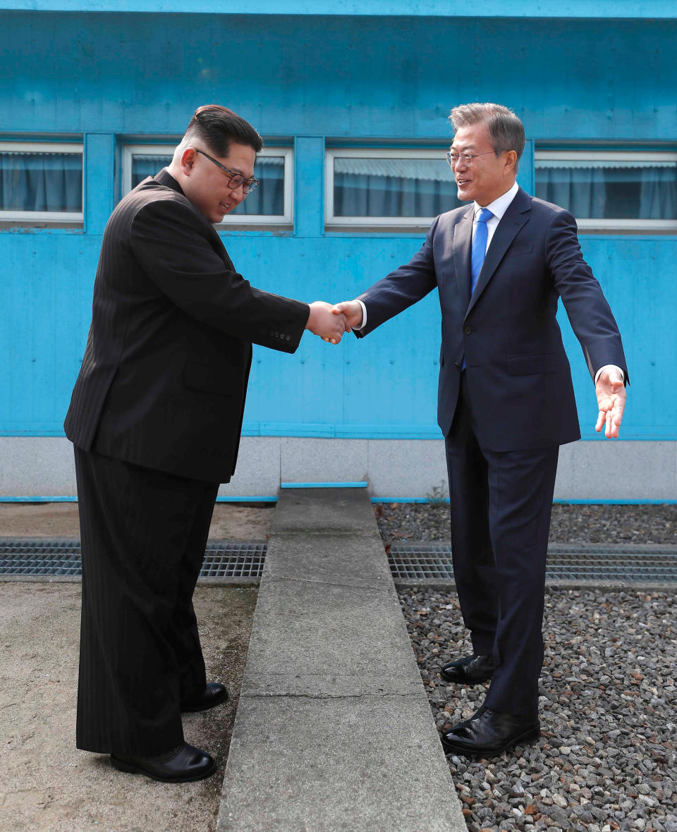 <p>North Korean leader Kim Jong Un, left, shakes hands with South Korean President Moon Jae-in over the military demarcation line at the border village of Panmunjom in Demilitarized Zone Friday, April 27, 2018. (Photo: Korea Summit Press Pool via AP) </p>