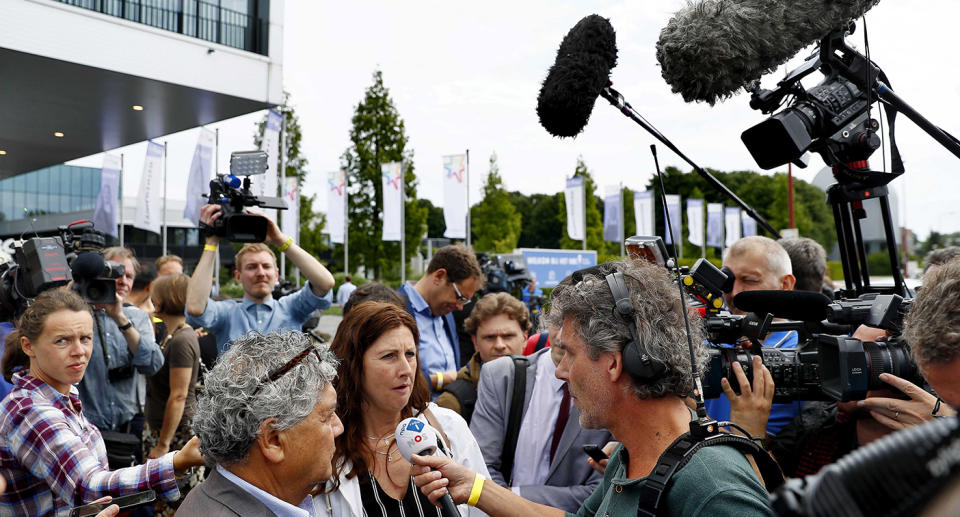 Surviving relatives surrounded by media at the press conference.