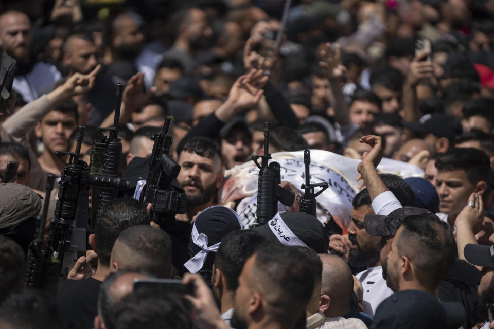 Palestinian militants wearing headbands that say, "Lions' Den," the name of a local armed group, take part in the funeral procession of three comrades who were killed by Israeli forces earlier this year, Odai Shami, Jihad Shami and Mohammad Dabik, in the West Bank city of Nablus, Saturday, May 6, 2023. The killing of Zuhair al-Ghaleeth last month, the first slaying of a suspected Israeli intelligence collaborator in the West Bank in nearly two decades, has laid bare the weakness of the Palestinian Authority and the strains that a recent surge in violence with Israel is beginning to exert within Palestinian communities. (AP Photo/Nasser Nasser)