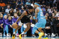 Los Angeles Clippers forward Paul George, left, drives into Charlotte Hornets guard Tre Mann during the first half of an NBA basketball game in Charlotte, N.C., Sunday, March 31, 2024. (AP Photo/Nell Redmond)