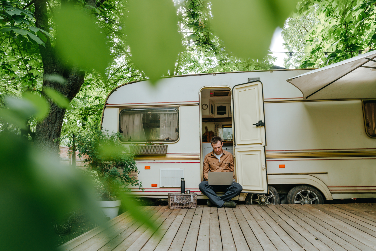 Man Working on Laptop While Sitting in RV in the Forest