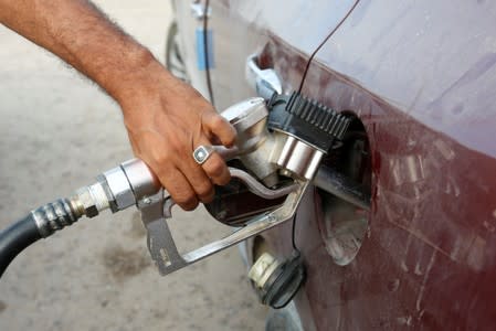 Employee of the state fuel distribution company, Brega, fills a car in Tripoli