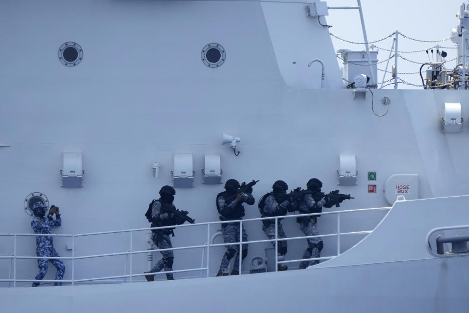 A Philippine Coast Guard personnel, left, participate in a drill on board the PCG Melchora Aquino ship off the waters of Bataan, Philippines., Tuesday, June 6, 2023. Philippines, U.S. and Japanese coast guard participated in exercises which involved drills on maritime law enforcement and security.(AP Photo/Aaron Favila)