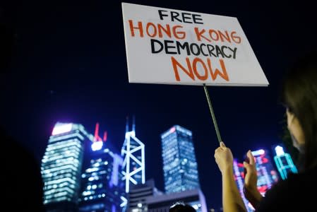 A demonstrator holds a placard during a rally ahead of the G20 summit, urging the international community to back their demands for the government to withdraw a the extradition bill in Hong Kong