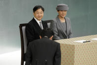 FILE - In this Aug. 15, 2019, file photo, Japanese Emperor Naruhito, and Empress Masako, look at Japanese Prime Minister Shinzo Abe bowing during a memorial ceremony for the war dead at Nippon Budokan Martial Arts Hall in Tokyo. (AP Photo/Eugene Hoshiko, File)