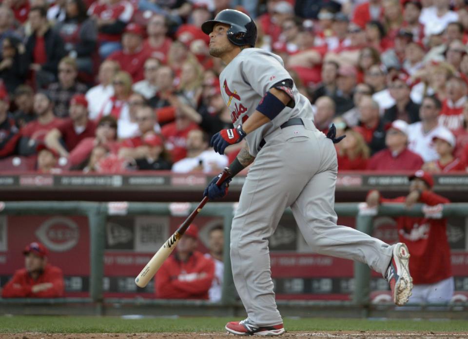 Yadier Molina de los Cardenales de San Luis batea un jonrón solitario ante los Rojos de Cincinnati el lunes 31 de marzo de 2014. (AP Foto/Michael Keating)